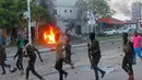 Petugas berjalan di dekat mobil yang terbakar setelah sebuah serangan bom mobil di sebuah restoran di Mogadishu, Somalia, (8/5). Setidaknya 6 orang tewas dan 10 orang lainnya terluka dalam serangan bom mobil tersebut. (AP Photo/Farah Abdi Warsameh)