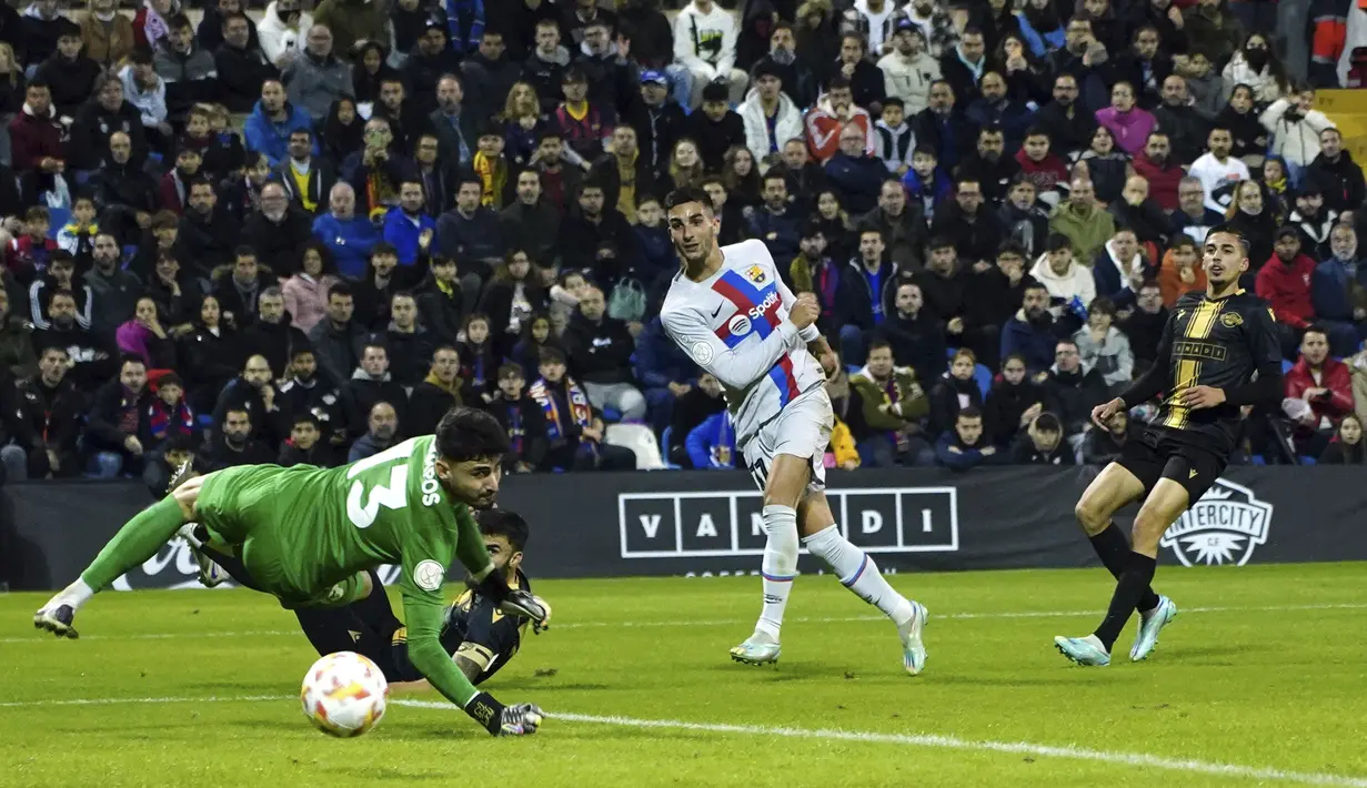 Penyerang Barcelona, Ferran Torres menembak bola melewati kiper Intercity Gaizka Campos selama pertandingan babak 32 besar Copa del Rey di stadion Ricardo Perez di Alicante, Spanyol, Kamis (5/1/2023). Blaugrana berhak melaju ke babak 16 besar Copa del Rey. (AP Photo/Alberto Saiz)