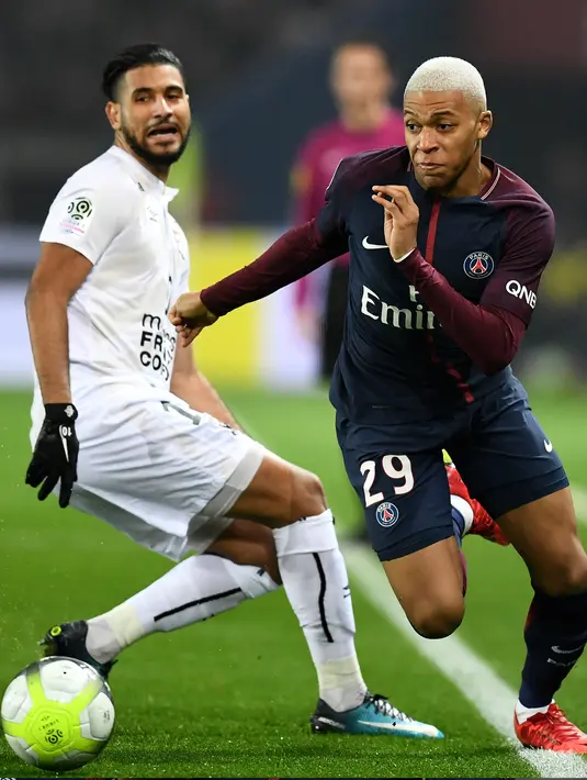 Kylian Mbappe berusaha melewati pemain Caen, Youssef Ait Bennasser saat bertanding pada lanjutan pertandingan Ligue 1 di Stadion Raymond-Kopa, di Angers, Prancis (20/12). PSG menang 3-1 atas Caen. (AFP Photo/Franck Fife)