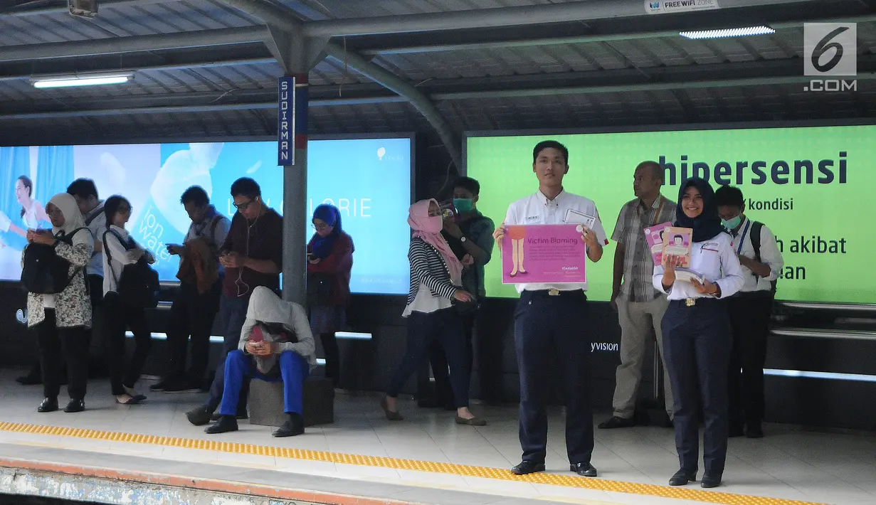 Pegawai PT KCI membawa poster saat kampanye bertema "Victim blamming, konsensus, cat call", dalam rangka memperingati Hari Perempuan Internasional di Stasiun Sudirman, Jakarta, Selasa (12/3). (Liputan6.com/Herman Zakharia)
