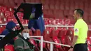 Wasit Stuart Attwell melihat monitor VAR pada pertandingan Liga Inggris antara Arsenal melawan Leeds United di Emirates Stadium, London, Inggris, Minggu (14/2/2021). Arsenal menyikat Leeds United 4-2 dengan hattrick dari Pierre-Emerick Aubameyang. (Catherine Ivill/Pool via AP)