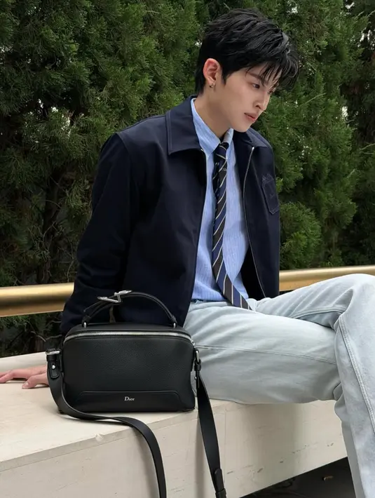 Pond Naravit juga memiliki Dior Archie Bag warns hitam, dipadukan dengan gaya kasual formal dsri atasan kemeja baby blue berdasi dipadukan outer jaket dan celana panjang denim. [@ppnaravit]