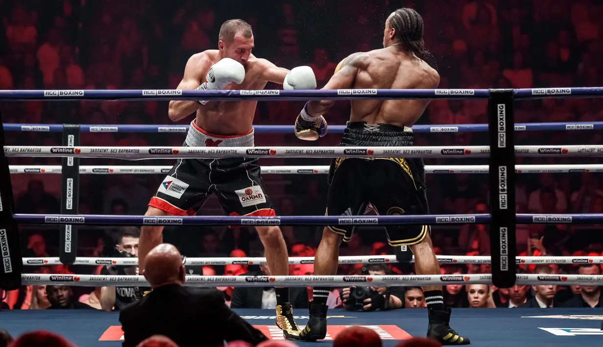 Petinju Rusia Sergey Kovalev (kiri) bertarung melawan petinju Inggris Anthony Yarde (kanan) selama pertarungan gelar juara kelas berat ringan WBO di Chelyabinsk, Rusia, Sabtu (24/8/2019). Kovalev merobohkan Yarde lewat KO di ronde 11. (AP Photo/Anton Basanayev)