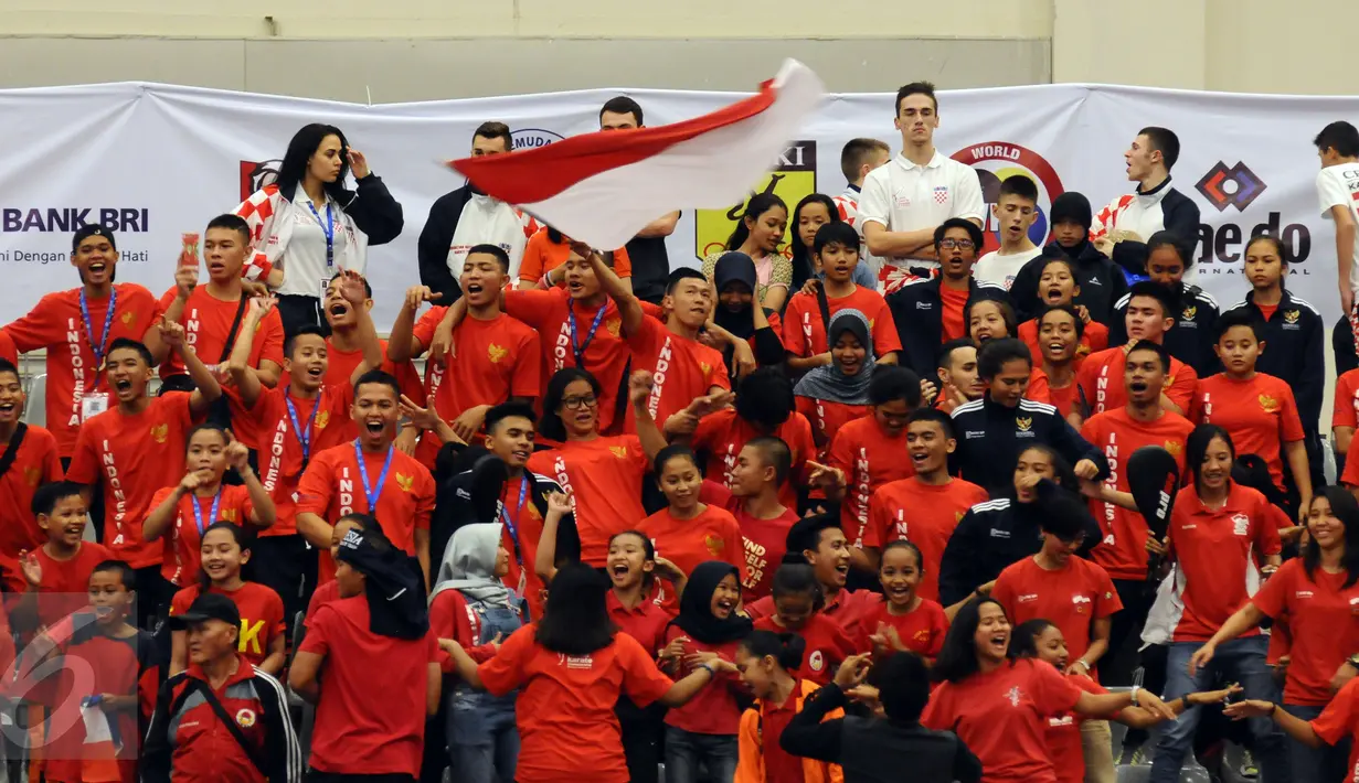 Sejumlah suporter Indonesia bersorak usai Ahmad ZigiZaresta memastikan kemenangan di final Junior Kata Male di WKF World Junior, Cadet and U-21 Championship 2015 di ICE Serpong, Kamis (12/11/2015). (Liputan6.com/Helmi Fithriansyah)