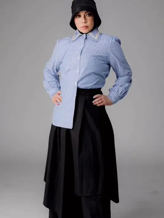 <p>Memadukan gaya ala modern victorian, rok panjang dan kemeja garis serta paduan bucket hat menampilkan gaya yang unik. (Foto: Melly Goeslaw/ Instagram)</p>