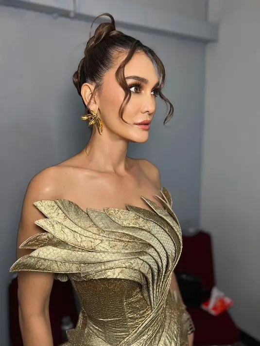 Rambut brunette Luna Maya ditata dengan twisted french updo yang sisakan curl bang di bagian depan [@hairbyranggayusuf]