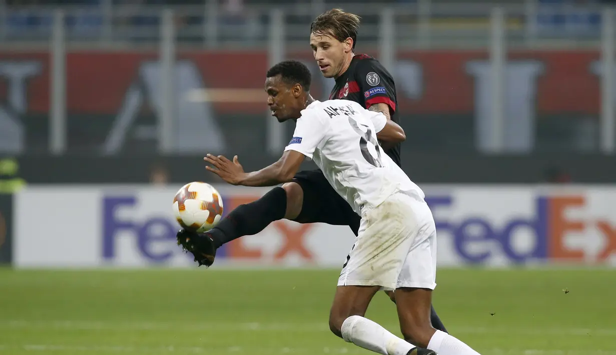 Aksi pemain AC Milan, Lucas Biglia (kanan) menghalau bola dari pemain Austria Wien, Abdullahi Ibrahim Alhassan pada laga grup D Liga Europa di San Siro stadium, Milan, (23/11/2017). Milan menang telak 5-1. (AP/Antonio Calanni)