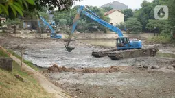 Petugas Sudin Sumber Daya Air (SDA) menggunakan alat berat untuk mengeruk lumpur yang mengendap di Setu Mangga Bolong, Jagakarsa, Jakarta, Rabu (2/9/2020). Pengerukan untuk meningkatkan fungsi setu sebagai tangkapan air, pengendali banjir dan penambahan daya tampung. (Liputan6.com/Immanuel Antonius)