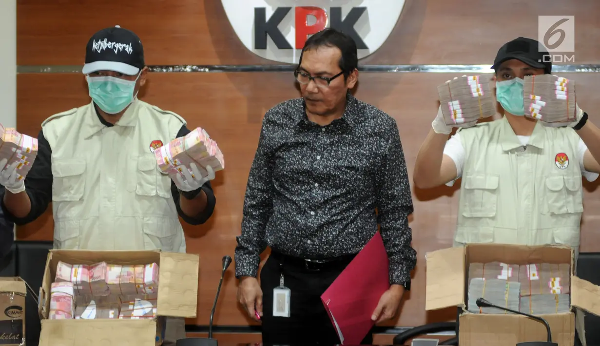 Wakil Ketua KPK Saut Situmorang bersama petugas menunjukkan barang bukti uang 2,5 Miliar hasil OTT di dua wilayah Kota Blitar dan Kabupaten Tulungagung, Jakarta, Jumat (9/6). (Merdeka.com/Dwi Narwoko)