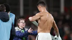 Penyerang Portugal Cristiano Ronaldo memberikan jerseynya untuk seorang fans cilik Irlandia yang berjalan ke lapangan pada akhir laga Grup A Kualifikasi Piala Dunia 2022 Zona Eropa di Stadion Aviva, Jumat (12/11/2021) dinihari WIB. Portugal ditahan imbang Irlandia 0-0. (AP /Peter Morrison)