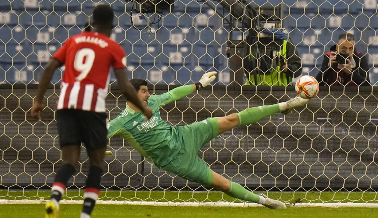Penjaga gawang Real Madrid Thibaut Courtois menyelamatkan tendangan penalti pemain Athletic Bilbao pada pertandingan sepak bola final Piala Super Spanyol di Stadion King Fahd, Riyadh, Arab Saudi, 16 Januari 2022. Real Madrid menang 2-0. (AP Photo/Hassan Ammar)