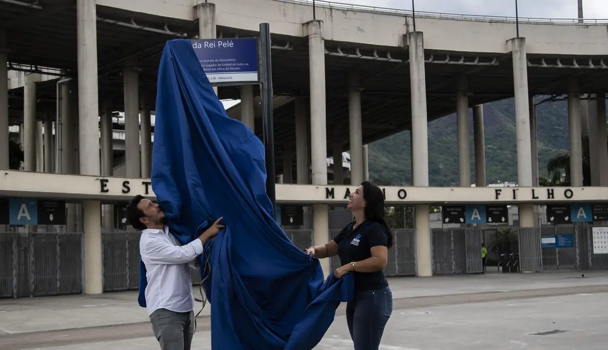 Personel Balai Kota membuka plang dengan nama baru jalan yang mengelilingi stadion Maracana, yang sekarang akan dikenal sebagai King Pele Avenue di Rio de Janeiro, Brasil, 4 Desember 2022. Perubahan nama tersebut sebagai penghargaan untuk legenda sepak bola Brasil, Edson Arantes do Nascimento atau lebih dikenal sebagai Pele. (AP Photo/Bruna Prado)
