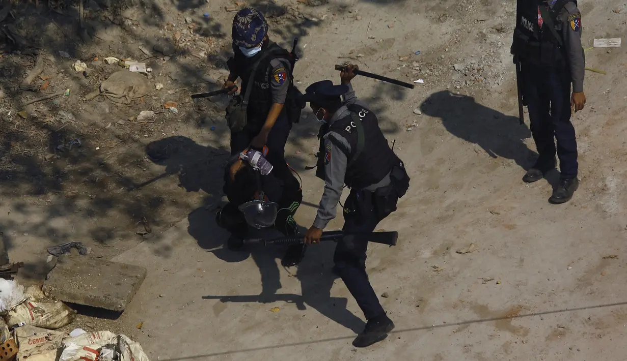 Polisi memukuli seorang pengunjuk rasa saat mereka menahannya selama demonstrasi menentang kudeta militer di Yangon, Sabtu (6/3/2021). Dikutip dari pernyataan PBB, lebih dari 1.700 orang telah ditangkap, termasuk 29 wartawan. (AFP Photo)