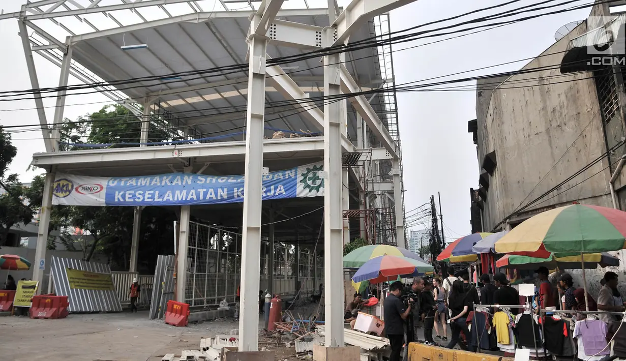 Pedagang kaki lima (PKL) berjualan dekat proyek pembangunan Skybridge Tanah Abang, Jakarta, Minggu (14/10). Saat ini progres pembangunan Skybridge Tanah Abang baru mencapai 75 persen. (Merdeka.com/Iqbal Nugroho)