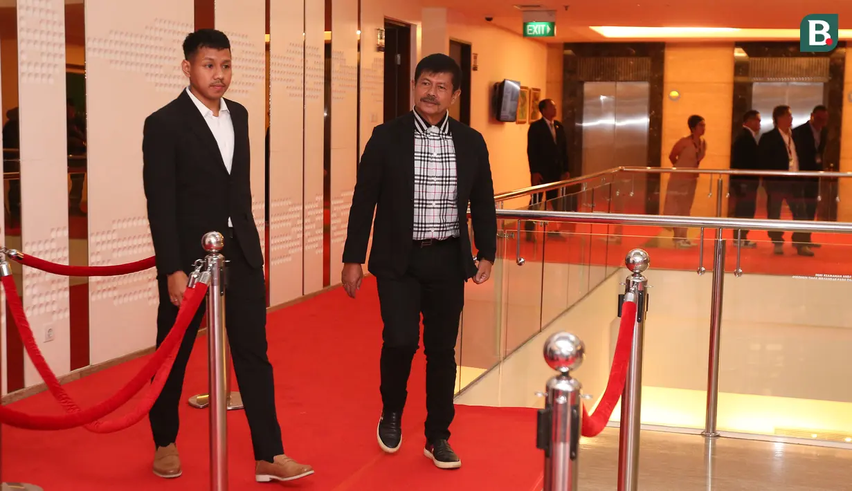 Pelatih kepala Timnas Indonesia U-22, Indra Sjafri berjalan di atas karpet merah pada sebuah acara yang berlangsung di Hotel JS Luwansa, Kuningan, Jakarta, Rabu (19/07/2023). Coach Indra terlihat mengenakan jas hitam dipadukan dengan kemeja kotak-kotak. (Bola.com/Bagaskara Lazuardi)