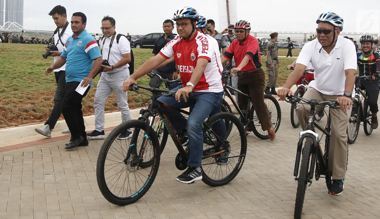 Gubernur DKI Jakarta Anies Baswedan bersepeda di kawasan Pantai Kita dan Pantai Maju, Minggu (23/12). Aksi itu mengawali Peletakkan Batu Pertama Jalur Jalan Sehat dan Sepeda Santai (Jalasena) di pulau reklamasi tersebut. (Liputan6.com/Herman Zakharia)