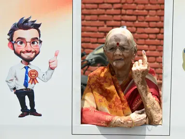 Seorang pemilih menunjukkan jarinya yang bertinta setelah memberikan suaranya dalam pemungutan suara tahap kedua pada pemilihan umum India di Ghaziabad pada 26 April 2024. (Sajjad HUSSAIN/AFP)