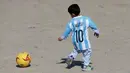 Murtaza Ahmadi (5), bocah asal Afghanistan, memakai jersey yang ditandatangani langsung oleh bintang Barcelona yang juga idolanya, Lionel Messi, ketika bermain sepak bola di sebuah lapangan terbuka di Kabul, Jumat (26/2). (REUTERS/Omar Sobhani)