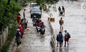 Pengendara dan pejalan kaki melewati perempatan Green Garden, Kedoya, Jakarta, Jumat (3/1/2020). Hingga hari ke-3, banjir masih menggenangi sekitar kawasan perempatan Green Garden, Kedoya akibatnya pengendara harus lebih waspada menghindari mesin kemasukan air. (Liputan6.com/Helmi Fithriansyah)