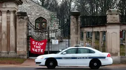 Petugas berjaga di depan gerbang Chesed Shel Emeth Cemetery di University City, St Louis, Missouri, (21/2). Otoritas Missouri sedang menyelidiki dibalik aksi vandalisme ini. (Robert Cohen /St. Louis Post-Dispatch via AP)