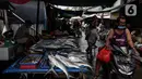 Pedagang ikan bandeng, salah satu makanan khas Imlek, menunggu pembeli di Kawasan Petak Sembilan, Glodok, Jakarta, Minggu (7/2/2021). Kelenteng tua seperti Toa Se Bio sebagai penanda bahwa komunitas Tionghoa di Glodok telah hidup dari generasi ke generasi. (Liputan6.com/Johan Tallo)