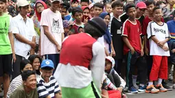 Pengunjung melihat penampilan seniman pantomin saat car free day di Jakarta, Minggu (1/7). Aksi tersebut dilakukan guna mengumpulkan biaya yang akan digunakan untuk menikah. (Liputan6.com/Immanuel Antonius)