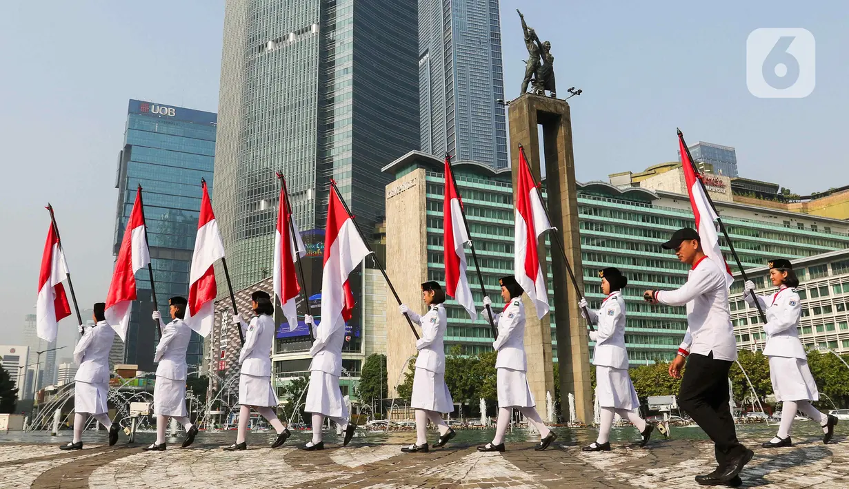 Sejumlah pasukan pengibar bendera (Paskibra) berbaris membawa bendera Merah Putih di Bundaran Hotel Indonesia (HI), Jakarta, Kamis (15/8/2024). (Liputan6.com/Herman Zakharia)