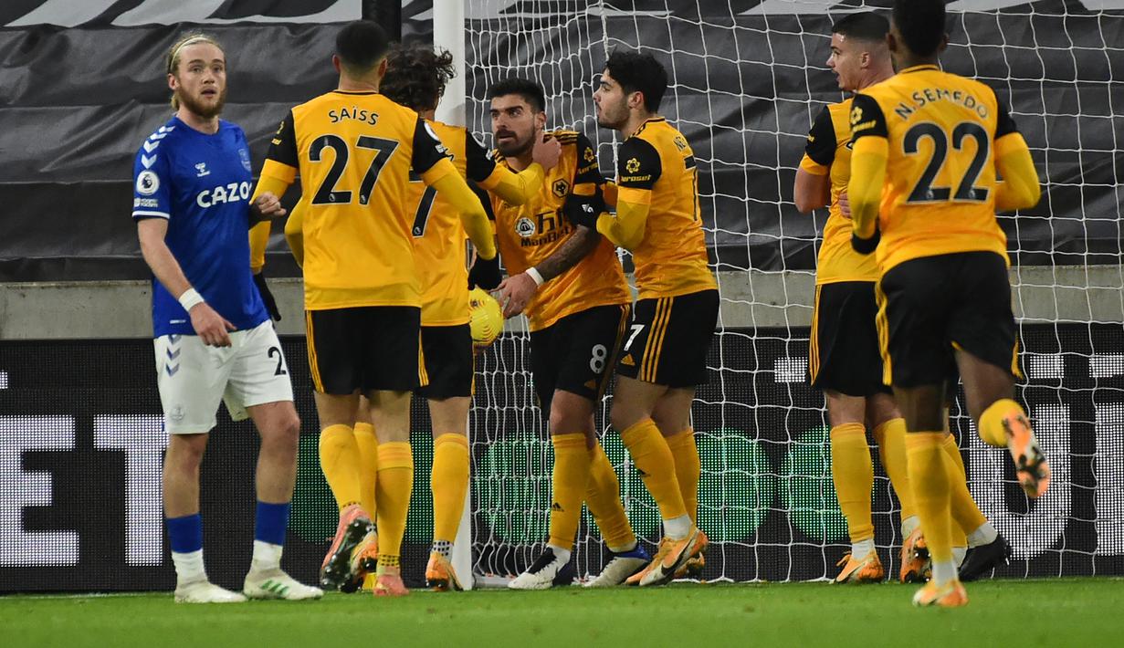 Gelandang Wolverhampton Wanderers, Ruben Neves (tengah) bersama rekan setim merayakan gol penyeimbang 1-1 ke gawang Everton dalam laga lanjutan Liga Inggris 2020/21 di Molineux Stadium, Selasa (12/1/2021). Wolverhampton Wanderers kalah 1-2 dari Everton. (AFP/Rui Vieira/Pool)