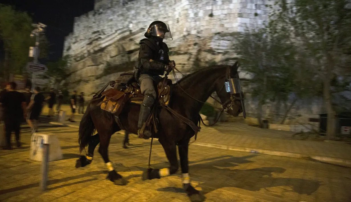 Polisi Israel menunggang kuda mengejar pemuda Palestina di dekat Gerbang Damaskus ke Kota Tua Yerusalem, selama bulan suci Ramadhan, Senin (19/4/2021). Polisi Israel bentrok dengan pengunjuk rasa Palestina, mengeluarkan meriam air dan kuda untuk membubarkan kerumunan. (AP Photo/Maya Alleruzzo)