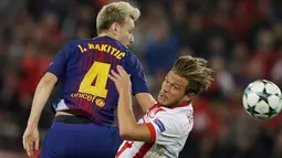 Pemain Barcelona, Ivan Rakitic berebut bola dengan pemain Olympiakos, Guillaume Gillet pada laga babak penyisihan Grup D Liga Champions di Georgios Karaiskáki, Rabu (1/11). Barcelona hanya mampu bermain imbang dengan skor 0-0. (AP/Thanassis Stavrakis)