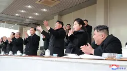 Pemimpin Korea Utara Kim Jong Un dan putrinya Kim Ju-ae bertepuk tangan saat menyaksikan pertandingan sepak bola antara staf Kabinet dan Kementerian Pertahanan Nasional, di Korea Utara pada 17 Februari 2023. Kim Jong Un mengajak putrinya dalam rangka merayakan ulang tahun kakeknya Kim Jong Il menandai penampilan pertama gadis itu yang tidak secara terbuka terkait dengan nuklir. (AFP/KCNA Via KNS)