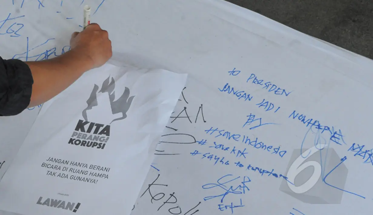 Pegawai KPK menuliskan dukungan unjuk rasa di halaman gedung KPK, Jakarta, Selasa (3/3/2015). Dalam aksinya, pegawai KPK menolak putusan Plt Pimpinan KPK yang melimpahkan kasus Komjen Pol Budi Gunawan ke Kejaksaan Agung. (Liputan6.com/Herman Zakharia)