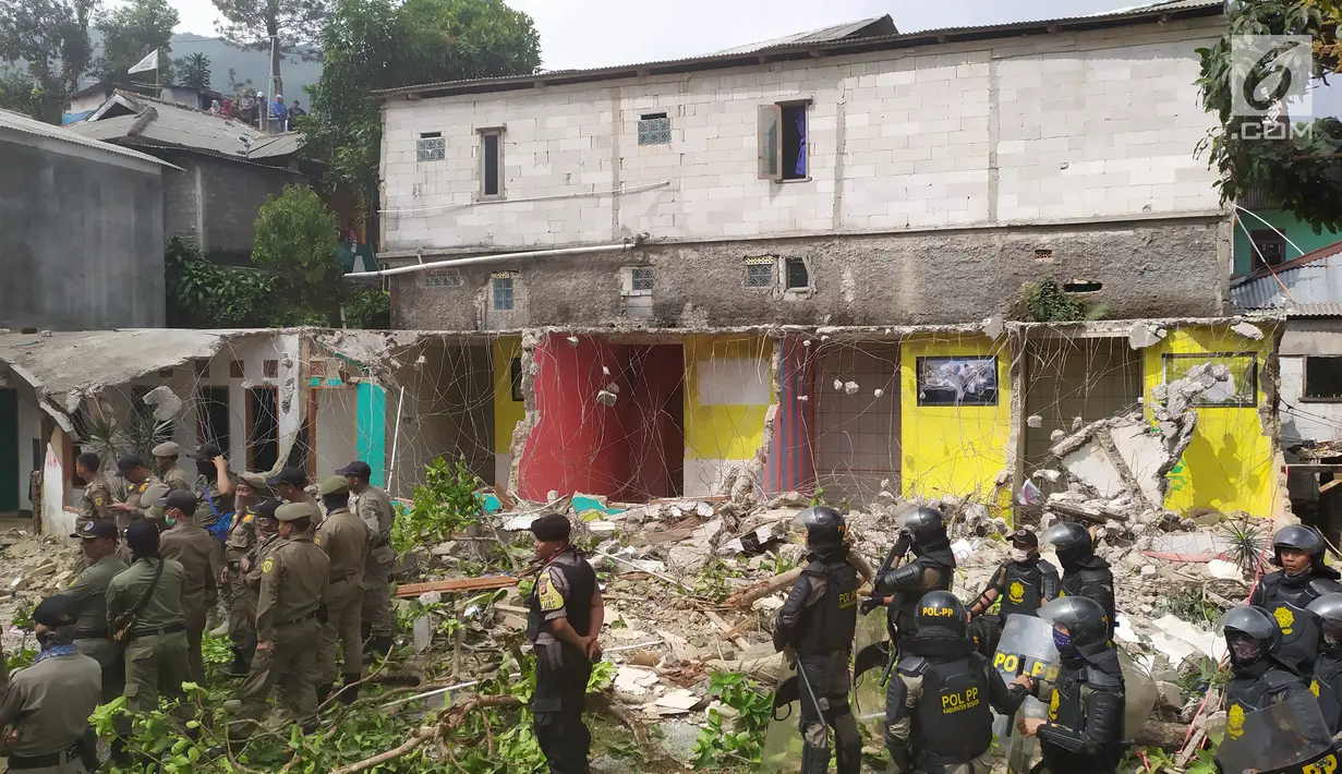 Petugas Satpol PP membongkar bangunan rumah di Kampung Naringgul, Kabupaten Bogor, Kamis (29/8/2019). Pembongkaran puluhan bangunan yang kerap digunakan sebagai penginapan jam-jaman hingga tempat mesum tersebut melibatkan 500 persenel gabungan. (Liputan6.com/Alby Azka)