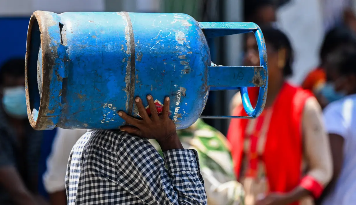 Warga membawa gas LPG di depan depo penjualan di tengah krisis ekonomi yang melanda di Kota Kolombo, Sri Lanka, Senin (23/5/2022). Pasokan gas terus menghadapi kekurangan akut, warga menunggu dalam antrean panjang untuk mendapatkan bahan bakar memasak. (AFP/ISHARA S. KODIKA)