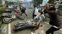 Massa merusak motor polisi yang terparkir di depan Gedung KPK, Jakarta, Jumat (20/5). Aksi menuntut KPK untuk segera mengusut keterlibatan Ahok di Sumber Waras ini berakhir ricuh. (Liputan6.com/Yoppy Renato)
