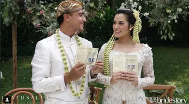 Penyanyi Raisa dan Hamish Daud menunjukkan buku pernikahan usai melangsungkan akad nikah. Minggu 3 September 2017 menjadi hari terindah Raisa dan Hamish Daud. Mereka mengikat janji suci sehidup semati. (Instagram/thebridestory)