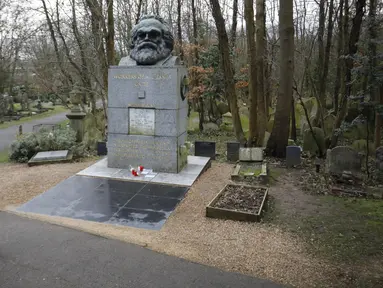 Pengunjung berjalan dekat makam filsuf ternama Jerman dan tokoh sosialisme, Karl Marx, di Pemakaman Highgate, London, Selasa (5/2). Nisan peringatan terbuat dari marmer yang menandakan persemayaman Marx dirusak oleh orang tidak dikenal. (Tolga AKMEN/AFP)