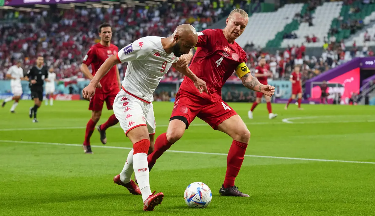 <p>Penyerang Tunisia, Issam Jebali berusaha membawa bola dari kawalan bek Denmark, Simon Kjaer selama pertandingan grup D Piala Dunia 2022 Qatar di Education City Stadium di Al Rayyan, Qatar, Selasa (22/11/2022). Tunisia dan Denmark sama-sama sempat mencetak gol di pertandingan ini. Namun, gol mereka dianulir wasit karena offside. (AP Photo/Petr David Josek)</p>
