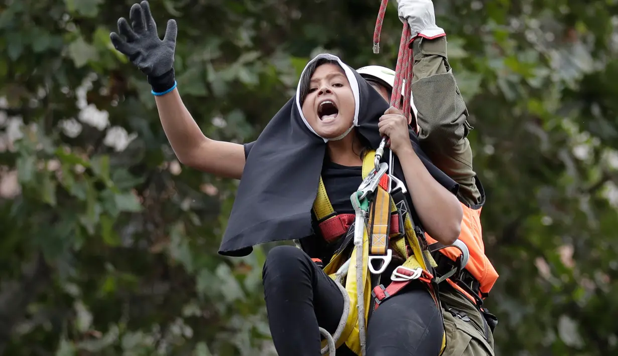 Petugas polisi setempat mengamankan akitivis yang melakukan protes serta memasang spanduk pro-aborsi jelang kedatangan Paus Fransiskus di Chili (15/1). (AP Photo / Victor R. Caivano)