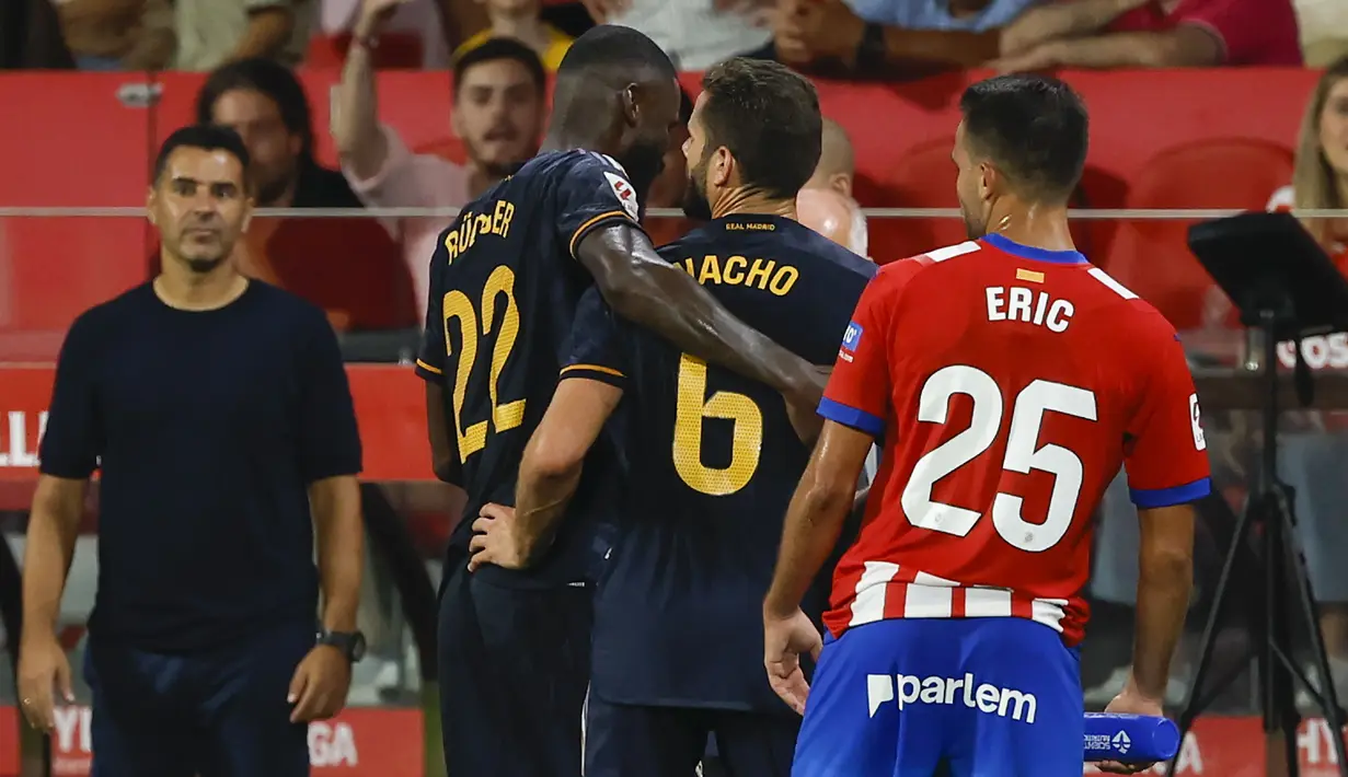 Bek Real Madrid, Antonio Rudiger (kiri) berusaha membujuk rekannya, Nacho untuk meninggalkan lapangan setelah diganjar kartu merah atas pelanggaran keras terhadap striker Girona, Portu pada laga pekan ke-8 Liga Spanyol 2023/2024 di Montilivi Stadium, Girona, Spanyol, Sabtu (30/9/2023) malam WIB. (AP Photo/Joan Monfort)
