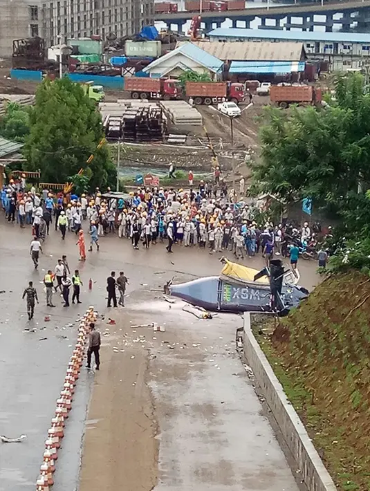 Sejumlah orang berkumpul di lokasi jatuhnya helikopter milik PT Indonesia Morowali Industrial Park (IMIP) di kawasan perusahaan di Morowali, Sulawesi Tengah, Jumat (20/4). Tujuh orang penumpang dan pilot selamat namun terluka. (Liputan6.com/Dok. BNBP)