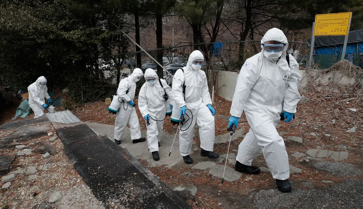 Tentara Korea Selatan yang mengenakan pakaian pelindung menyemprotkan cairan desinfektan di Seoul, Selasa (3/3/2020). Seoul mengerahkan tentara untuk menyemprotkan disinfektan di jalan dan gang-gang untuk mencegah penyebaran virus corona COVID-19. (AP Photo/Lee Jin-man)