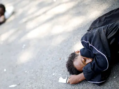 Seorang imigran tidur di luar stasiun kereta api Milan, 11 Juni 2015. Ratusan imigran yang baru diselamatkan beberapa pekan lalu dari laut oleh Italia ini hidup terlantar di sepanjang jalan. (REUTERS/Alessandro Bianchi) 