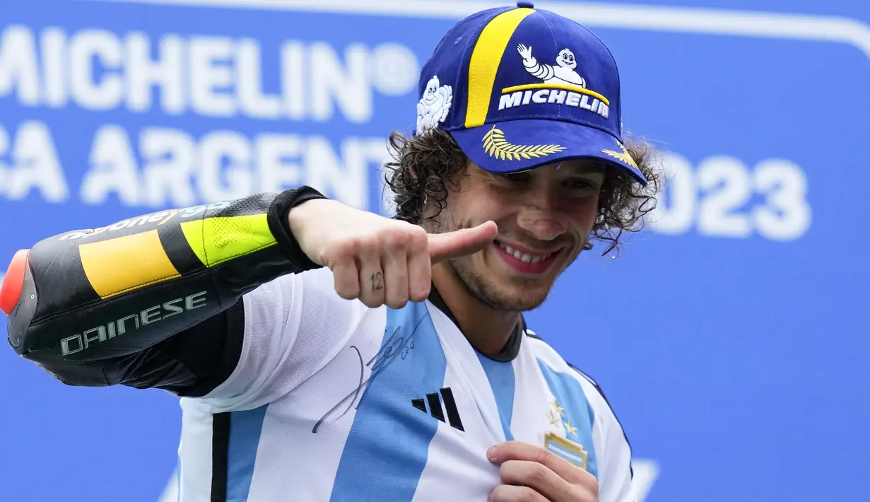 Pebalap Tim Mooney VR46, Marco Bezzecchi mengenakan jersey Timnas Argentina bertandatangan Lionel Messi saat menjuarai MotoGP Argentina 2023 di Autódromo Termas de Río Hondo, Argentina, Senin (03/04/2023) dini hari WIB. Selebrasi tersebut diketahui meniru sang gurunya, Valentino Rossi yang dilakukan pada musim 2015 silam. (AP Photo/Natacha Pisarenko)