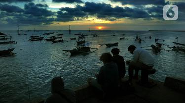 Warga memancing ikan saat matahari terbenam di Pantai Kedongnan, Bali, Senin (6/9/2021). Masa pandemi dimanfaatkan warga yang kehilangan pekerjaan untuk memancing, dimana hasilnya digunakan sebagai pelengkap lauk makan di rumah. (merdeka.com/Arie Basuki)