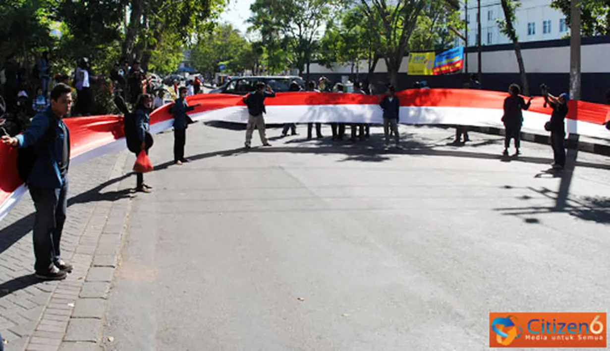 Citizen6, Surabaya: FAM Unair menggelar Aksi Arak-arakan Bendera Merah Putih sepanjang 54 Meter dan Penutupan jalan Airlangga Depan Pintu Masuk Kampus B Unair selama 54 Menit 54 detik, Senin (4/7). (Pengirim: Nias Stovit)