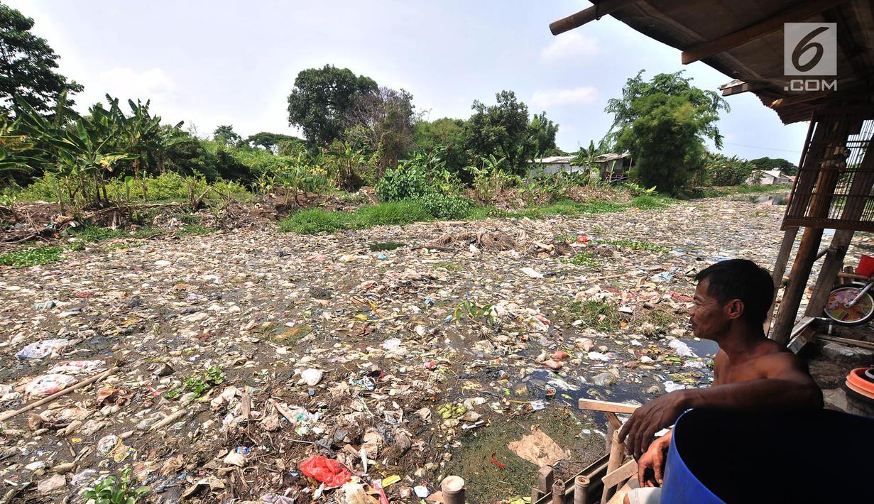 Warga melihat Kali Pisang Batu yang dipenuhi sampah, Tarumajaya, Bekasi, Jawa Barat, Rabu (9/1). Warga tetap beraktivitas sehari-hari meski bau tak sedap menghantui mereka akibat tumpukan sampah di Kali Pisang Batu. (Merdeka.com/Iqbal S. Nugroho)