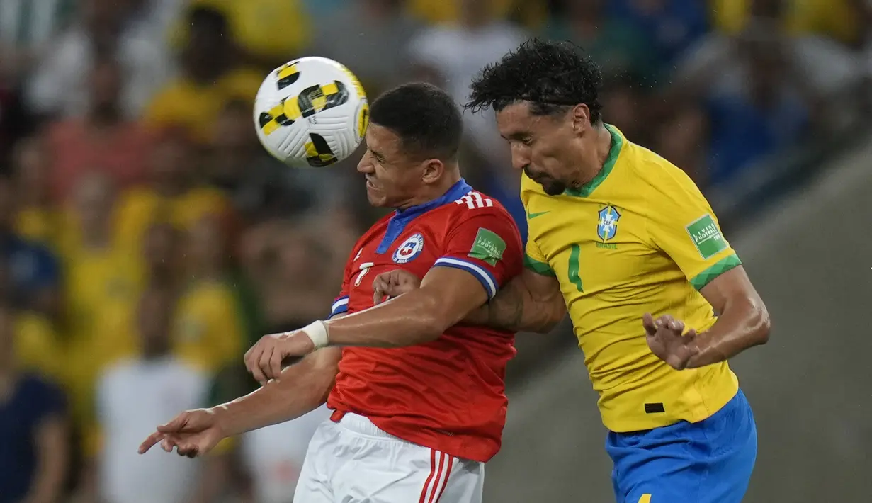 Penyerang Chile, Alexis Sanchez berebut bola udara dengan bek Brasil, Marquinhos selama pertandingan kualifikasi Piala Dunia 2022  zona CONMEBOL di stadion Maracana di Rio de Janeiro, Brasil, Jumat (25/3/2022). Brasil menang atas Chile 4-0.  (AP Photo/Silvia Izquierdo)