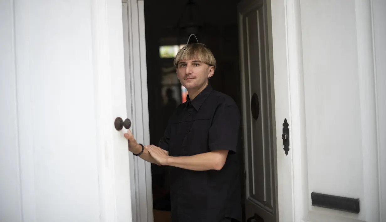 Neil Harbisson, orang pertama di dunia yang memasang antena di tengkoraknya, berpose di Mataro dekat Barcelona pada 23 September 2021. Antena tersebut ditanamkan dan osseointegrasi di kepala Harbisson dan tumbuh dari dalam tulang oksipitalnya. (Josep LAGO / AFP)