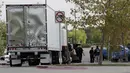 Polisi San Antonio selidiki sebuah truk yang berada di lapangan parkir supermarket, Texas, Minggu (23/7).  Total sebanyak 39 orang diperkirakan merupakan korban perdagangan manusia ditemukan berdesakan di dalam truk yang pengap itu. (AP Photo/Eric Gay)